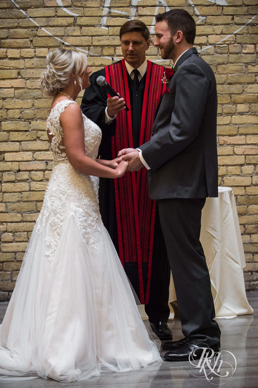 Bride and groom read vows during wedding ceremony at the Lumber Exchange Event Center in Minneapolis, Minnesota.