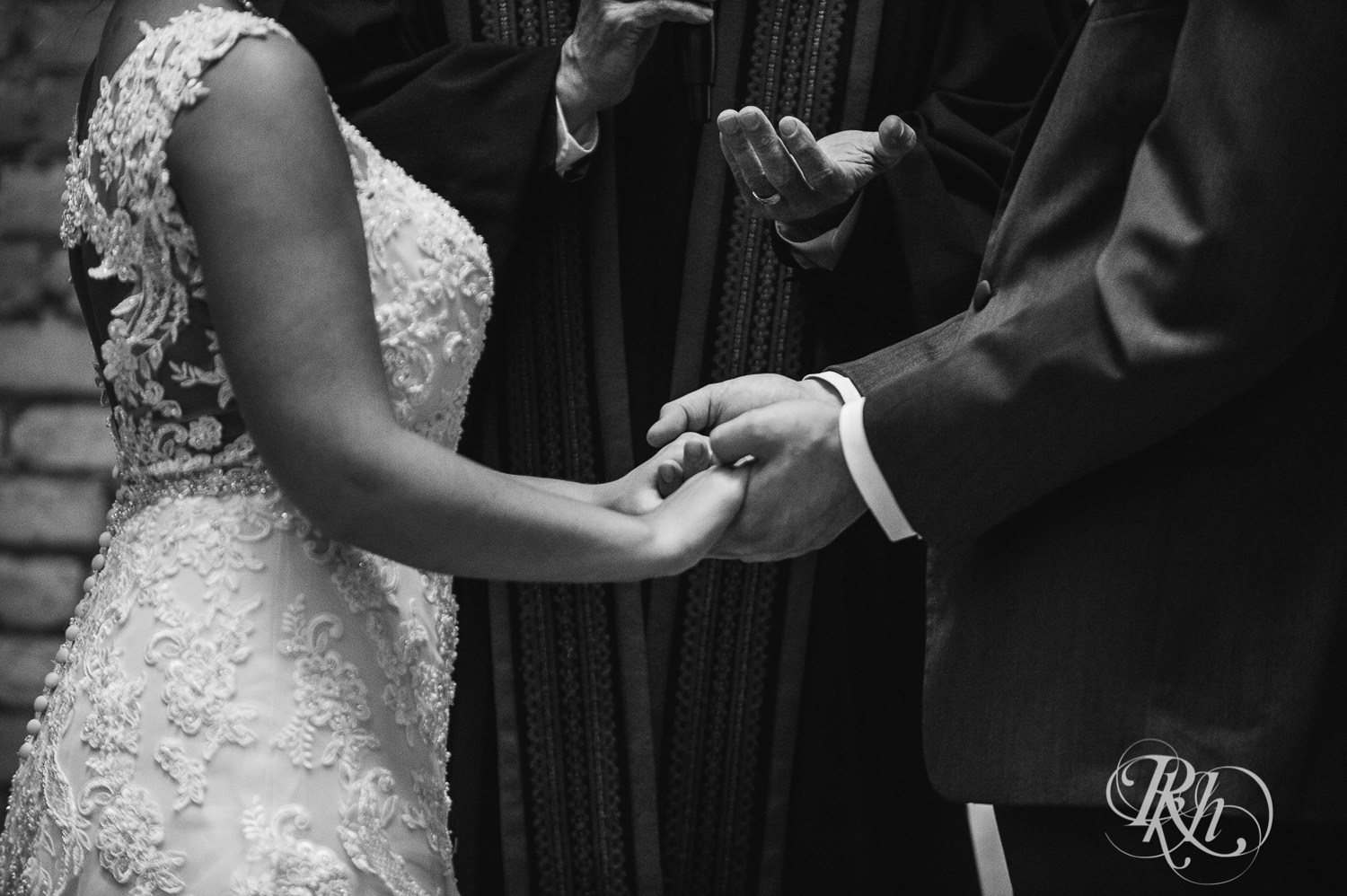 Bride and groom hold hands during wedding ceremony at the Lumber Exchange Event Center in Minneapolis, Minnesota.