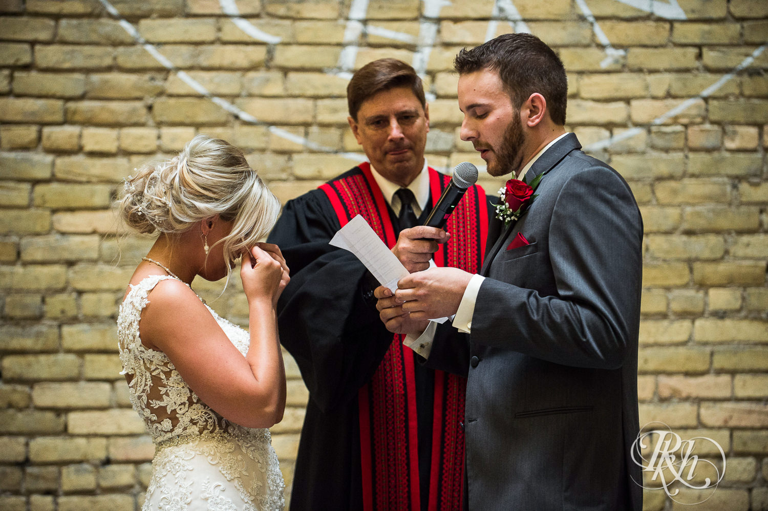 Bride and groom read vows during wedding ceremony at the Lumber Exchange Event Center in Minneapolis, Minnesota.
