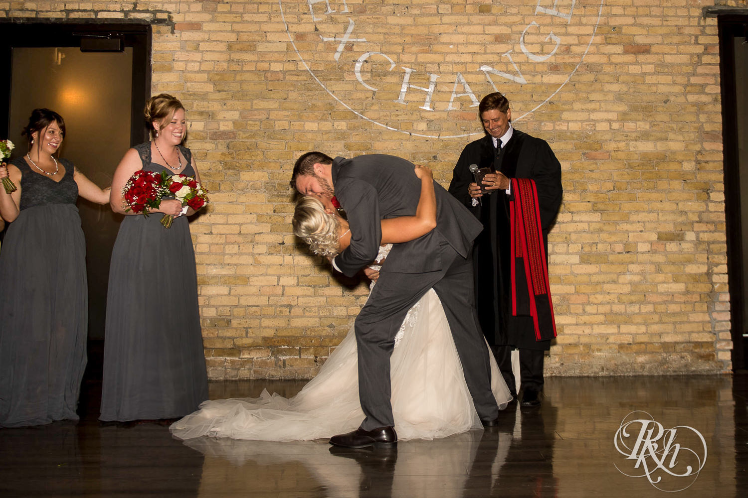 Bride and groom kiss during wedding ceremony at the Lumber Exchange Event Center in Minneapolis, Minnesota.