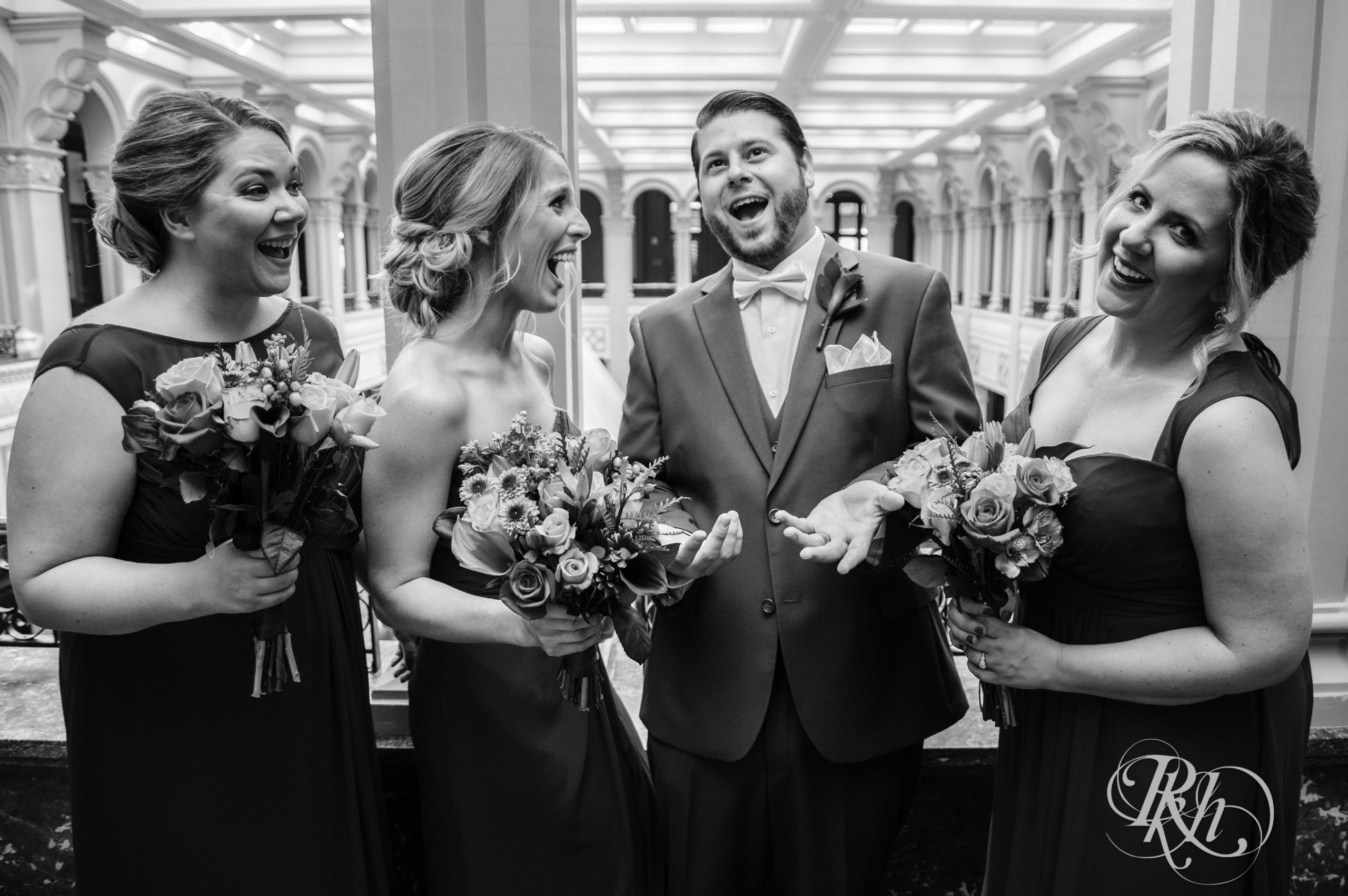 Groom smiles with wedding party at Landmark Center in Saint Paul, Minnesota.