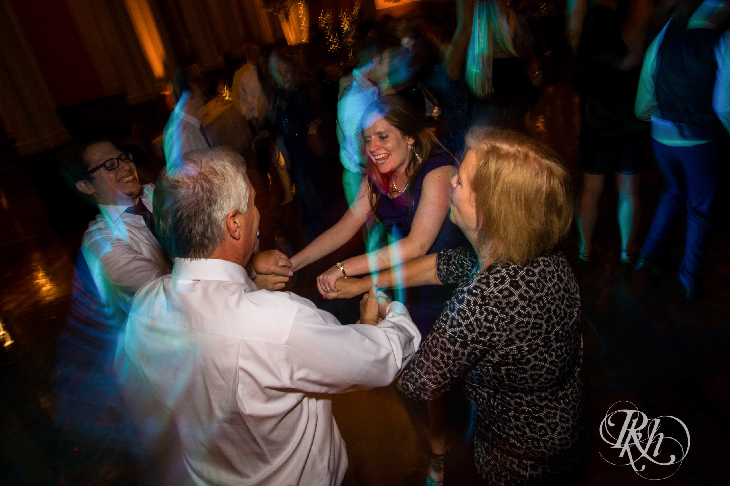 Guests dance during wedding reception on wedding day at Landmark Center in Saint Paul, Minnesota.
