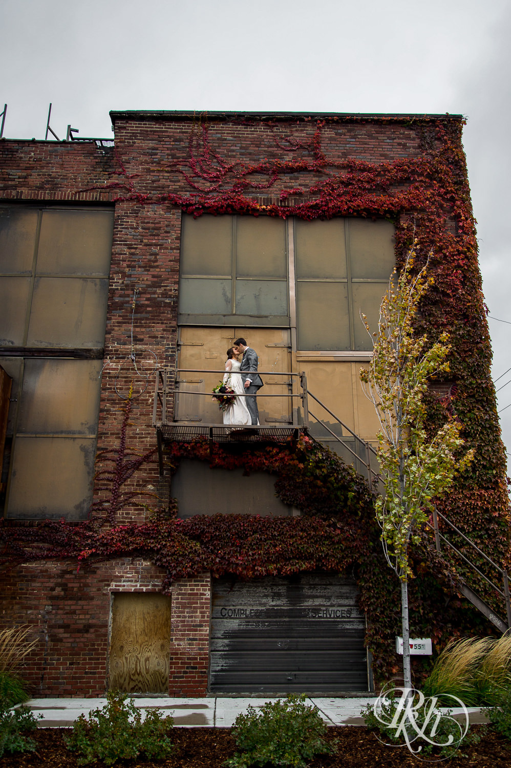 Bride and groom kiss on stairs on a rainy wedding day in Minneapolis, Minnesota.