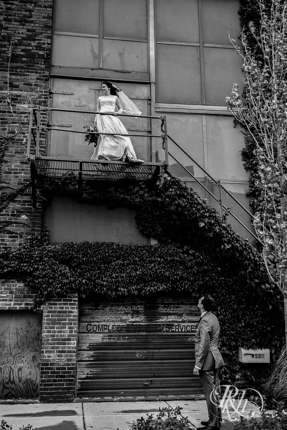 Bride and groom stand on stairs on a rainy wedding day in Minneapolis, Minnesota.