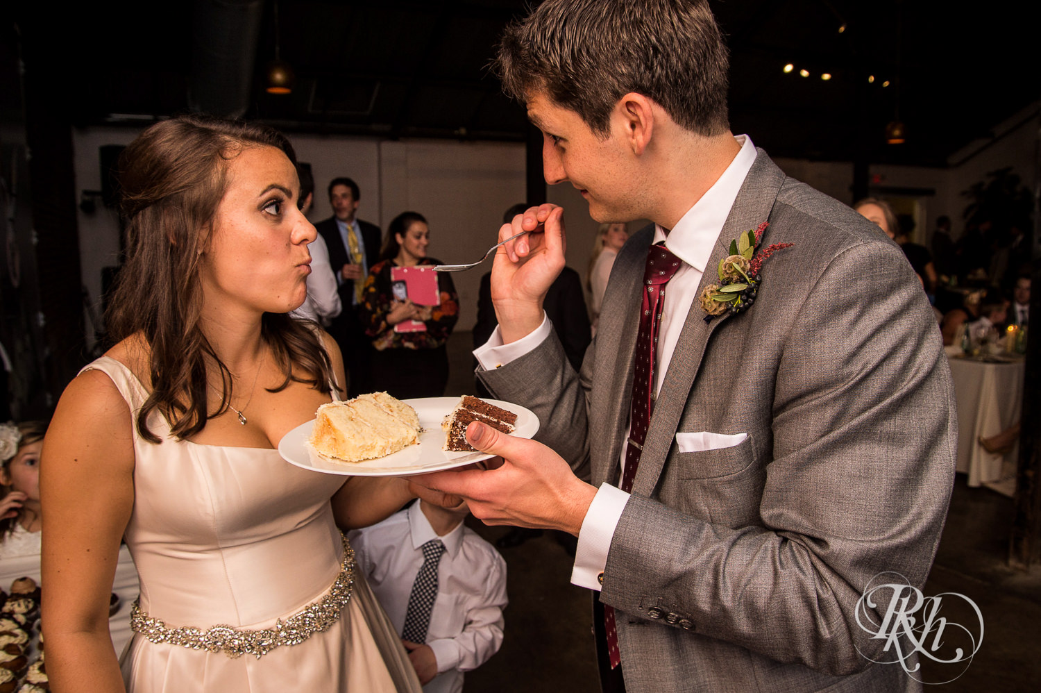 Bride and groom feed each other cake during wedding reception speeches at Paikka in Saint Paul, Minnesota.