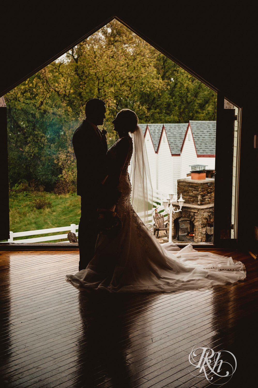 Silhouette of bride and groom in front of large window at Green Acres Event Center barn wedding in Eden Prairie, Minnesota.