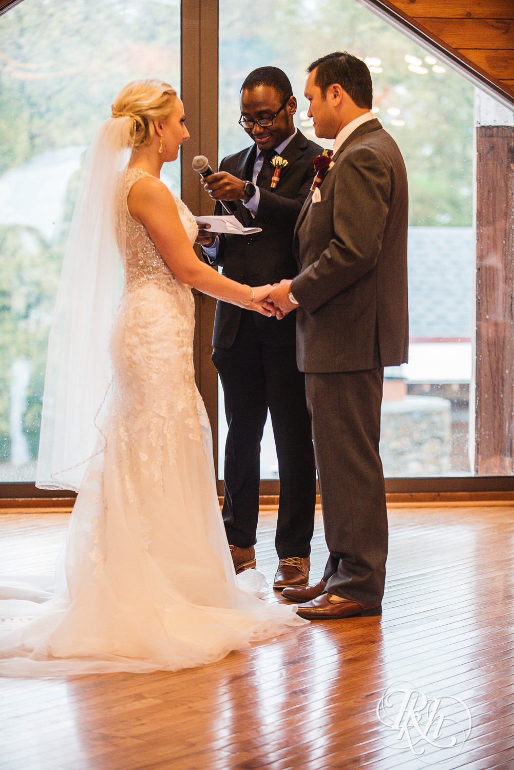 Bride and groom read vows at Green Acres Event Center barn wedding ceremony in Eden Prairie, Minnesota.