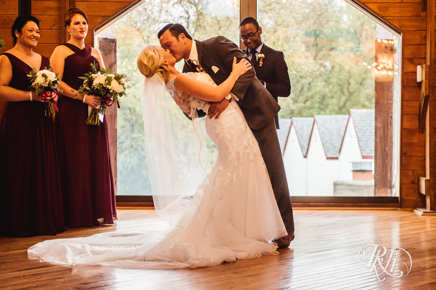 Bride and groom kiss at Green Acres Event Center barn wedding ceremony in Eden Prairie, Minnesota.