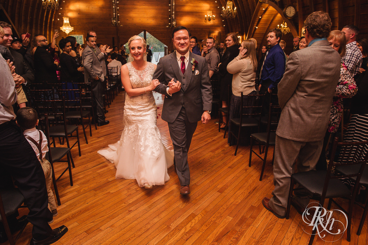Bride and groom walk down aisle at Green Acres Event Center barn wedding ceremony in Eden Prairie, Minnesota.