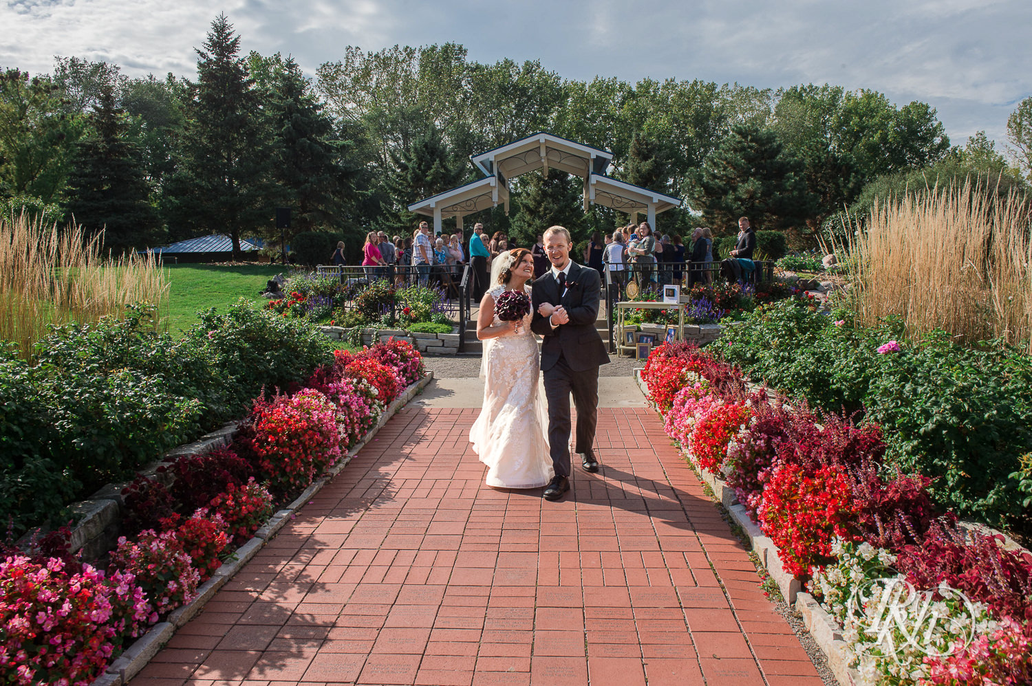 Bride and groom walk down the aisle after ceremony on wedding day at park in White Bear Lake, Minnesota.