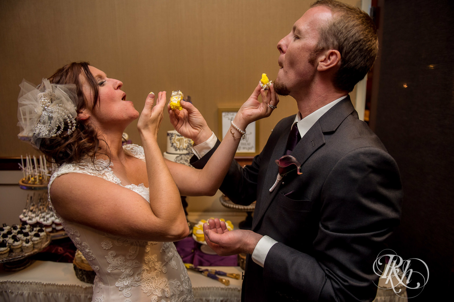Bride and groom feed each other cake during wedding reception at White Bear Country Inn in White Bear Lake, Minnesota.