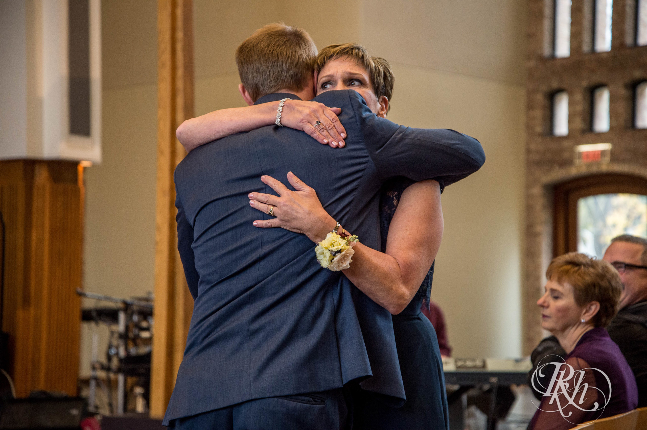 Groom and mom walk down the aisle at wedding ceremony in Minneapolis, Minnesota.