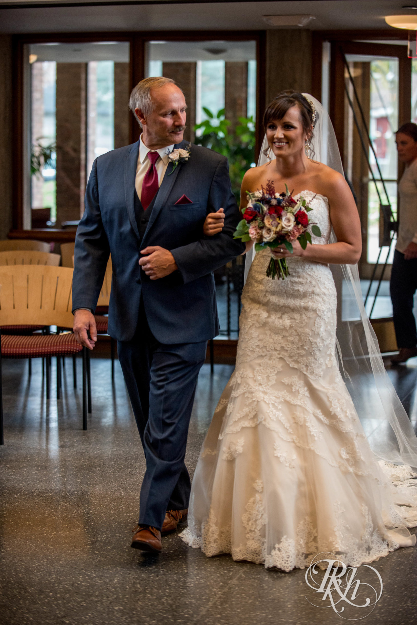 Bride and dad walk down the aisle at wedding ceremony in Minneapolis, Minnesota.