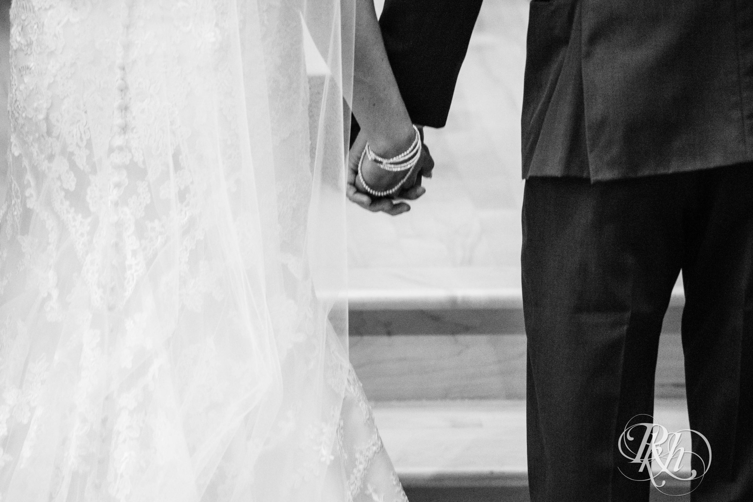 Bride and groom hold hands at wedding ceremony in Minneapolis, Minnesota.