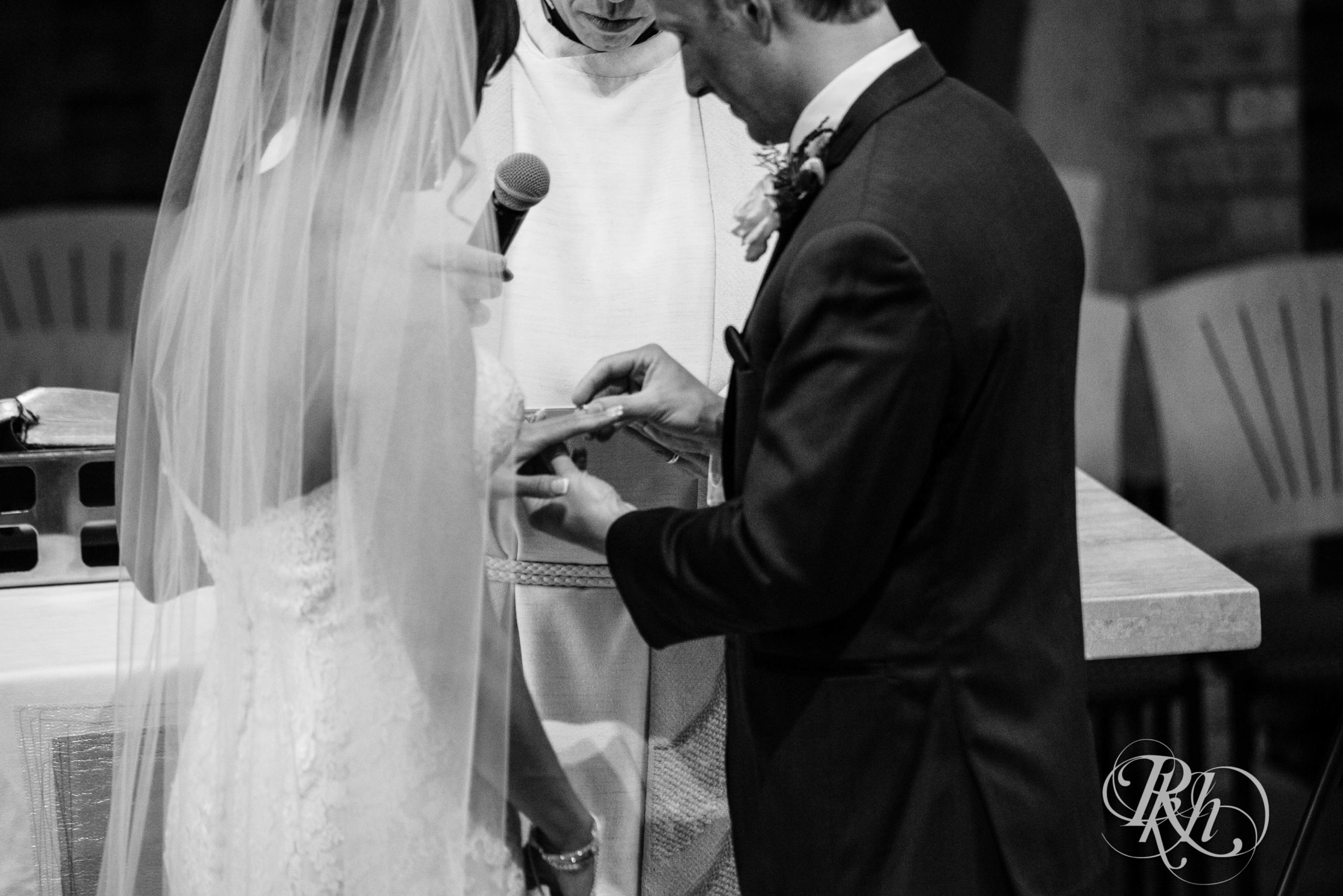 Bride and groom exchange rings at church wedding ceremony in Minneapolis, Minnesota.