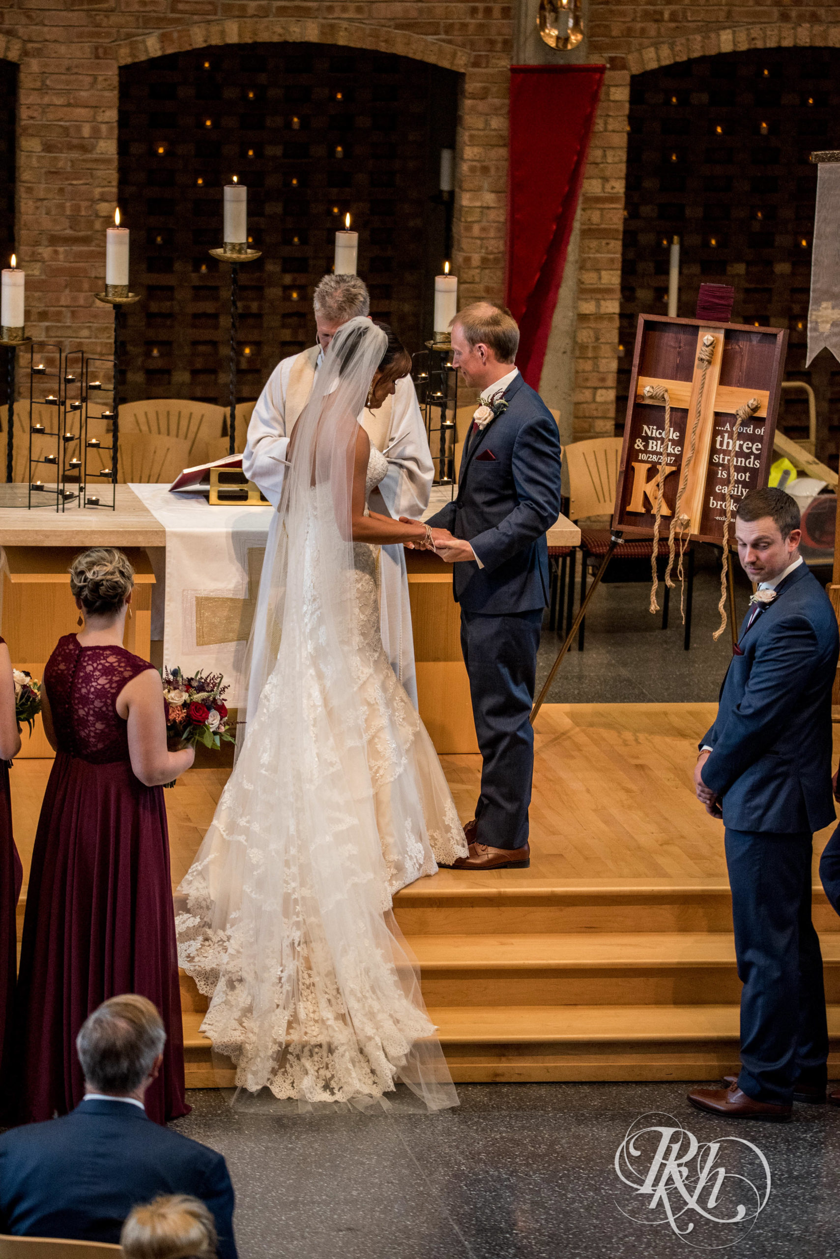 Bride and groom exchange rings at church wedding ceremony in Minneapolis, Minnesota.