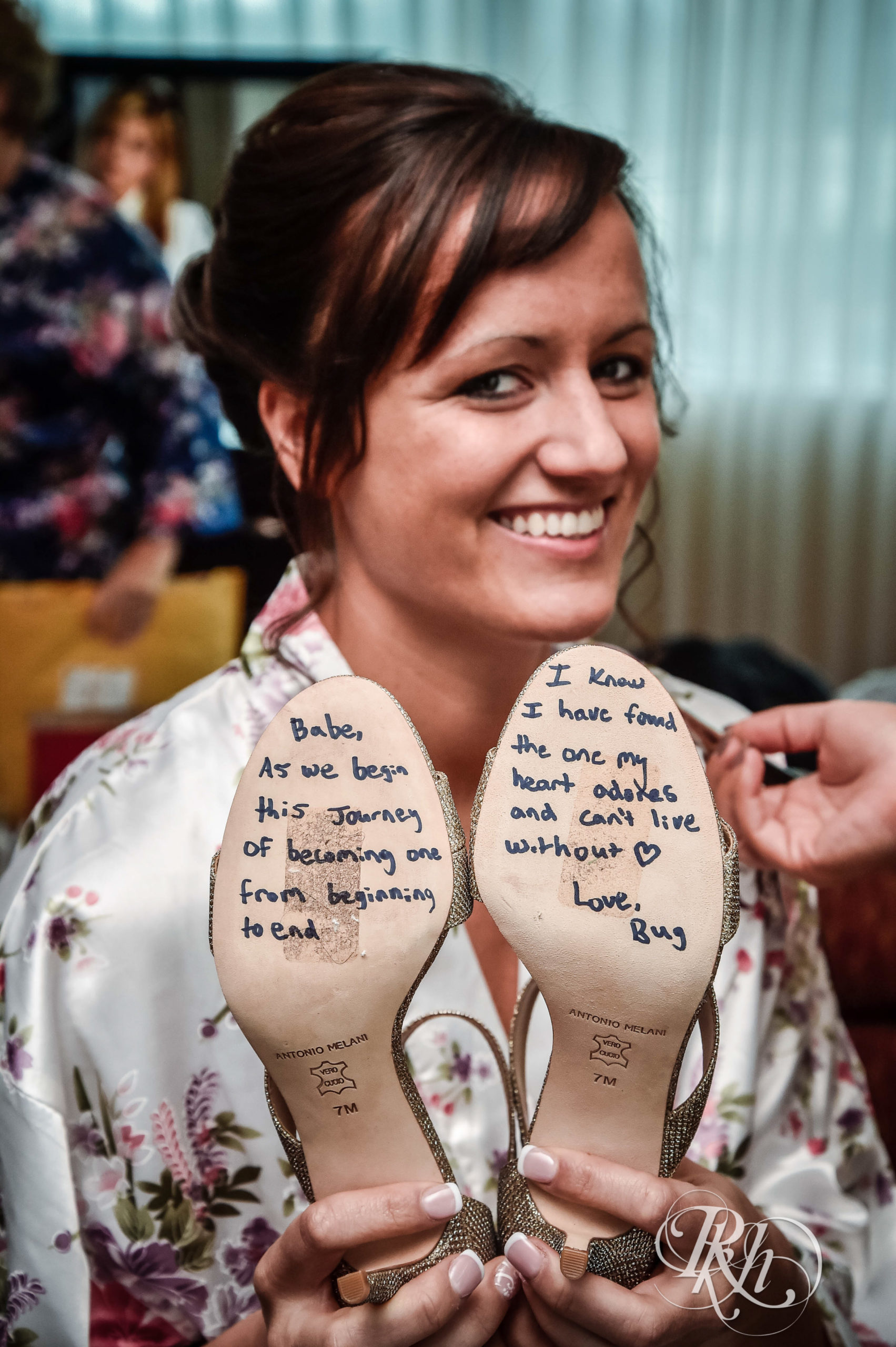 Bride shows shoes with vow on the bottom to the camera.