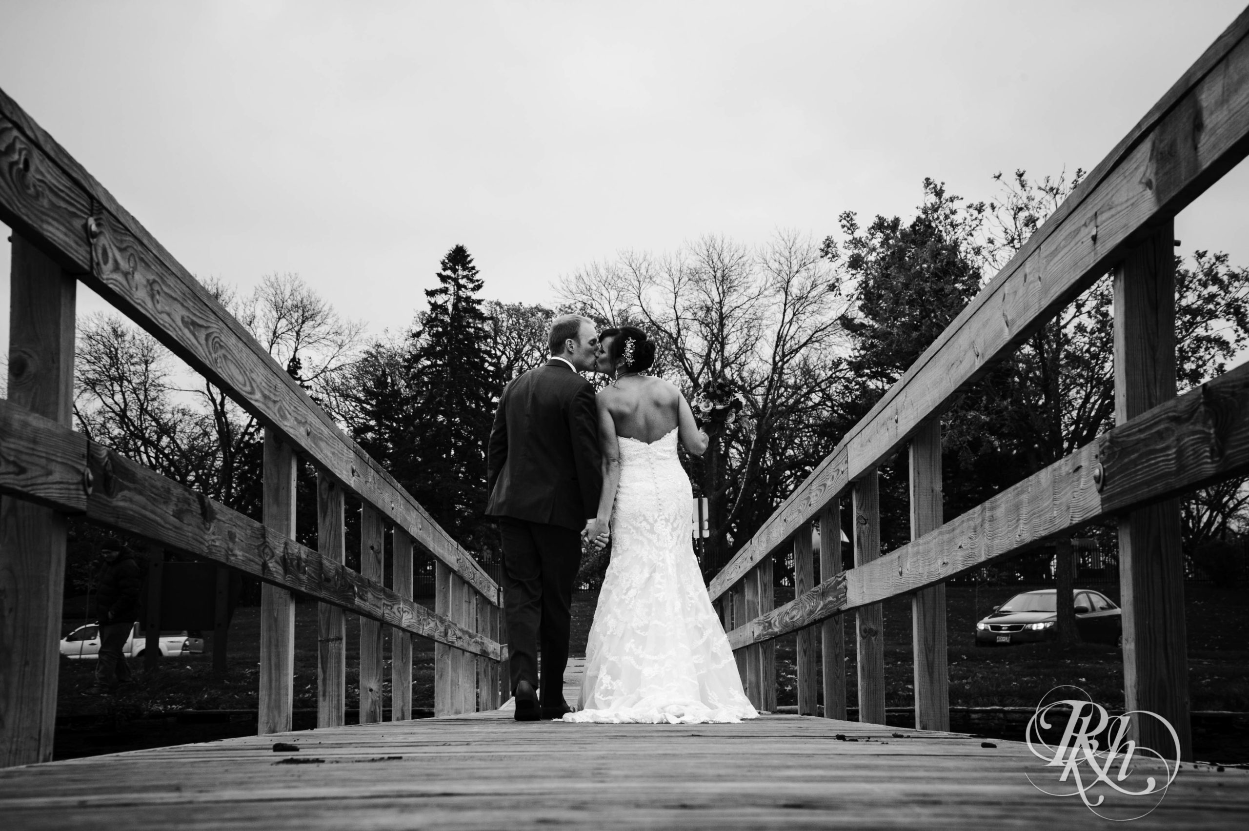 Bride and groom kiss on bridge on wedding day in Minneapolis, Minnesota.