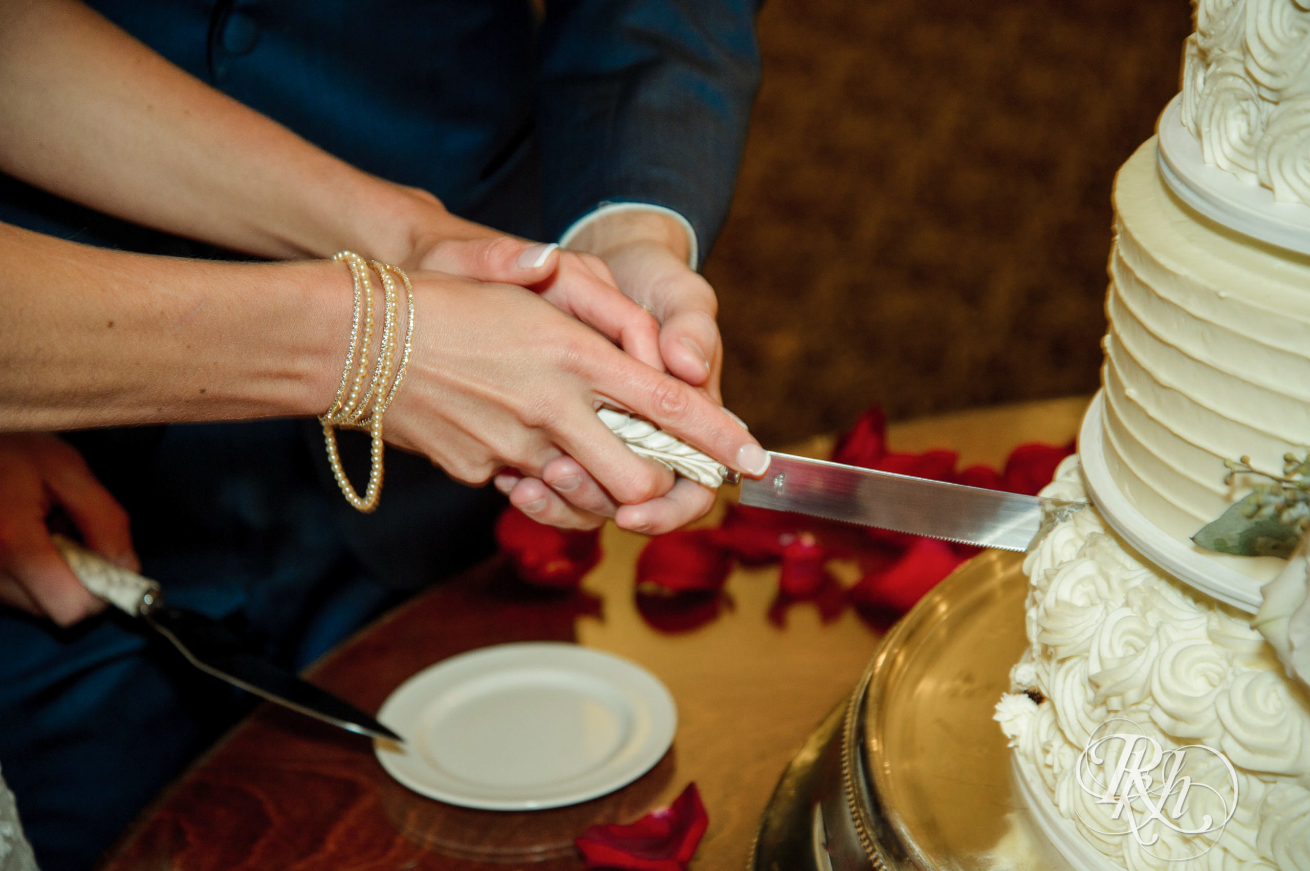 Bride and groom cut cake on fall wedding day at Minneapolis Golf Club in Minneapolis, Minnesota.