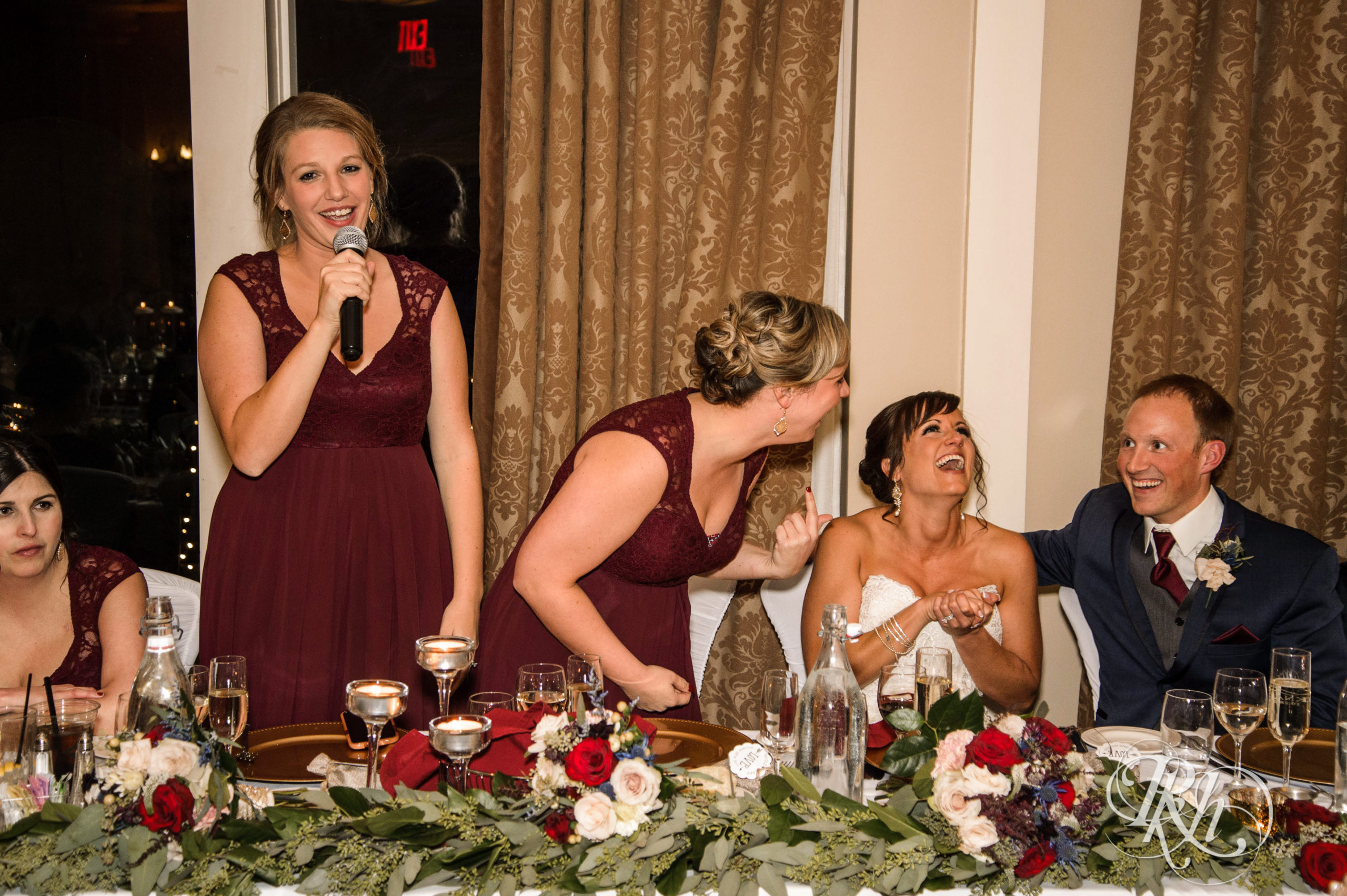 Bride and groom laugh during speeches on fall wedding day at Minneapolis Golf Club in Minneapolis, Minnesota.