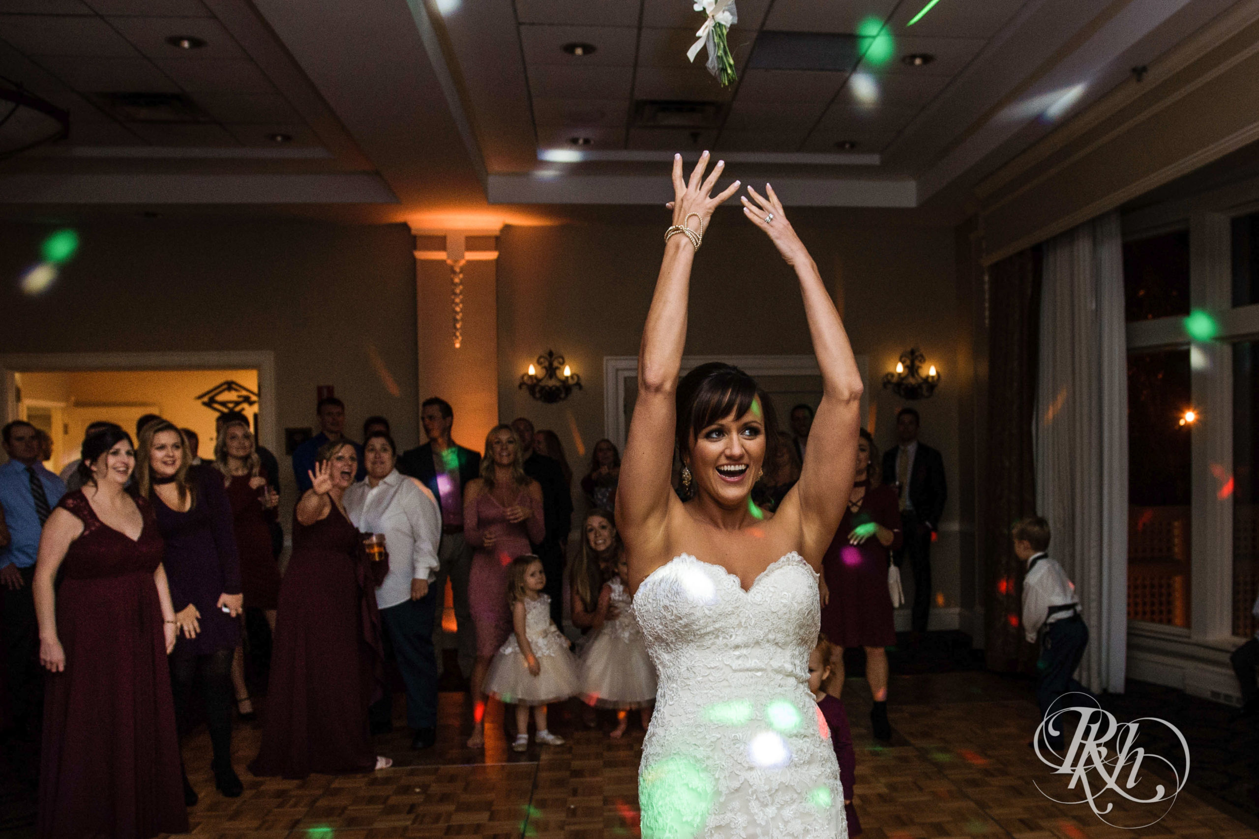 Bride throws bouquet on fall wedding day at Minneapolis Golf Club in Minneapolis, Minnesota.