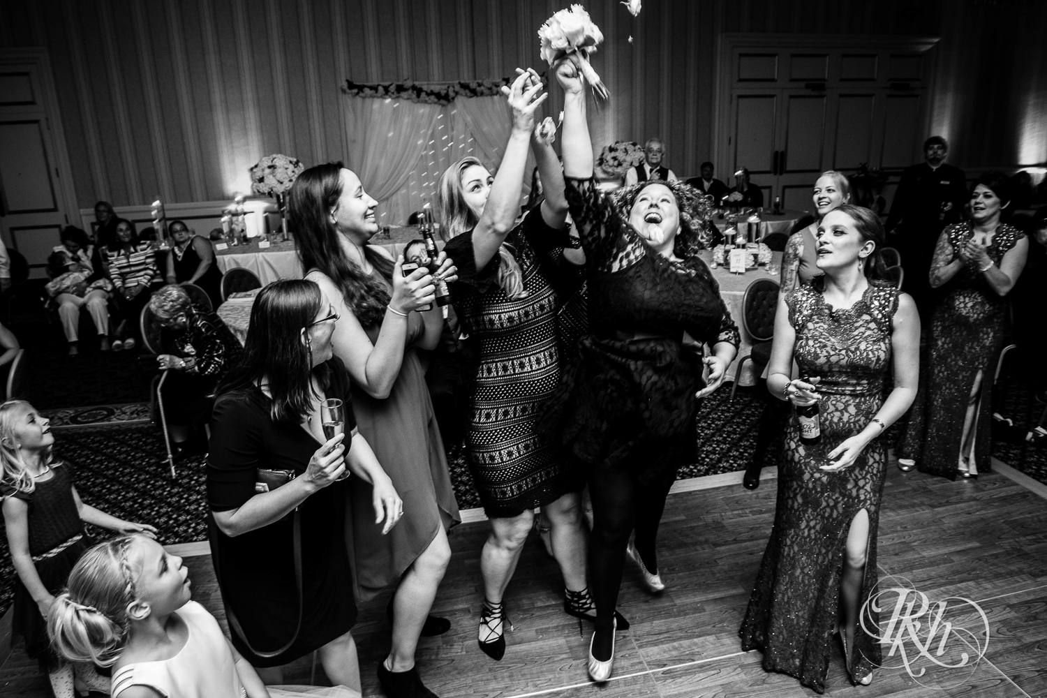 Guests catch bouquet at wedding reception at The Saint Paul Hotel in Saint Paul, Minnesota.