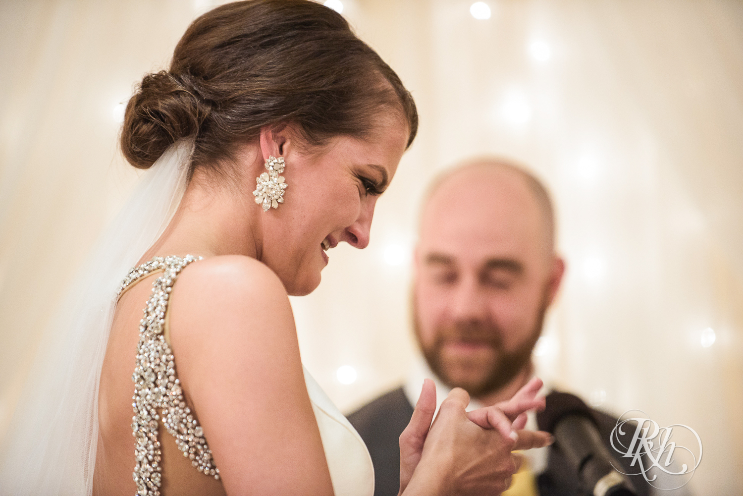 Bride and groom smile during wedding ceremony at The Saint Paul Hotel in Saint Paul, Minnesota.
