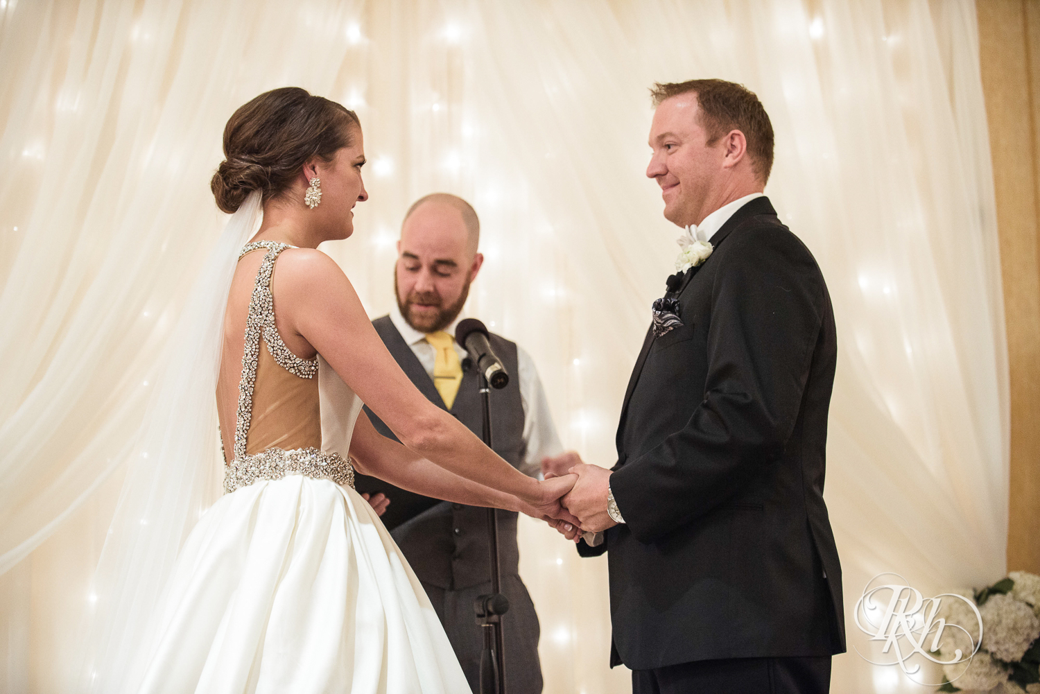 Bride and groom smile during wedding ceremony at The Saint Paul Hotel in Saint Paul, Minnesota.