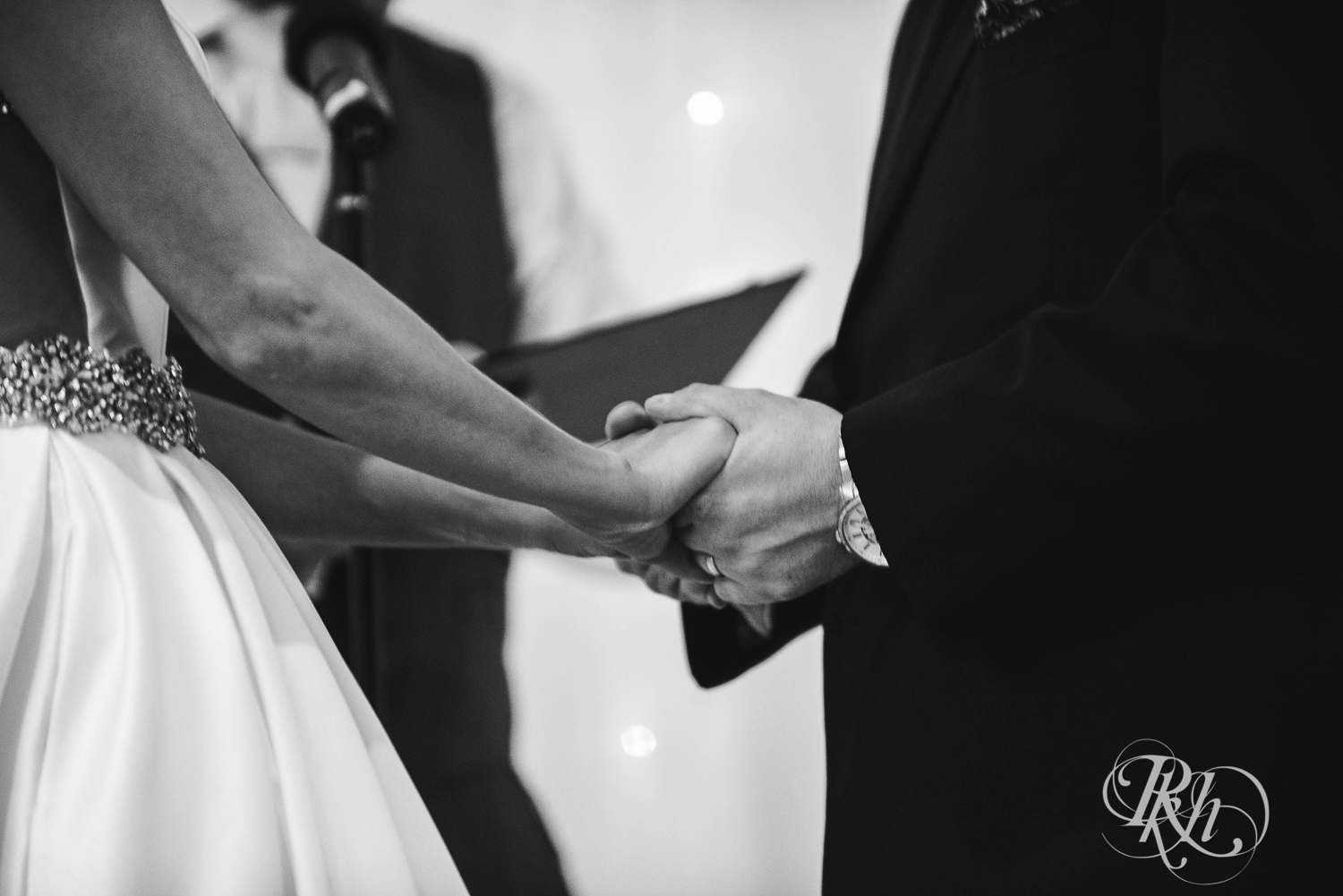 Bride and groom hold hands during wedding ceremony at The Saint Paul Hotel in Saint Paul, Minnesota.