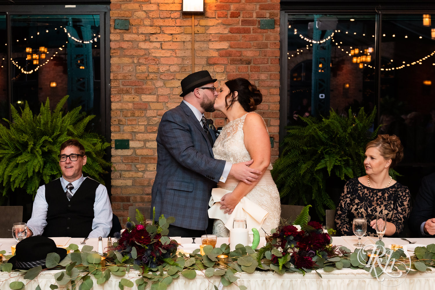 Bride and groom kiss during wedding reception at Nicollet Island Pavilion in Minneapolis, Minnesota.