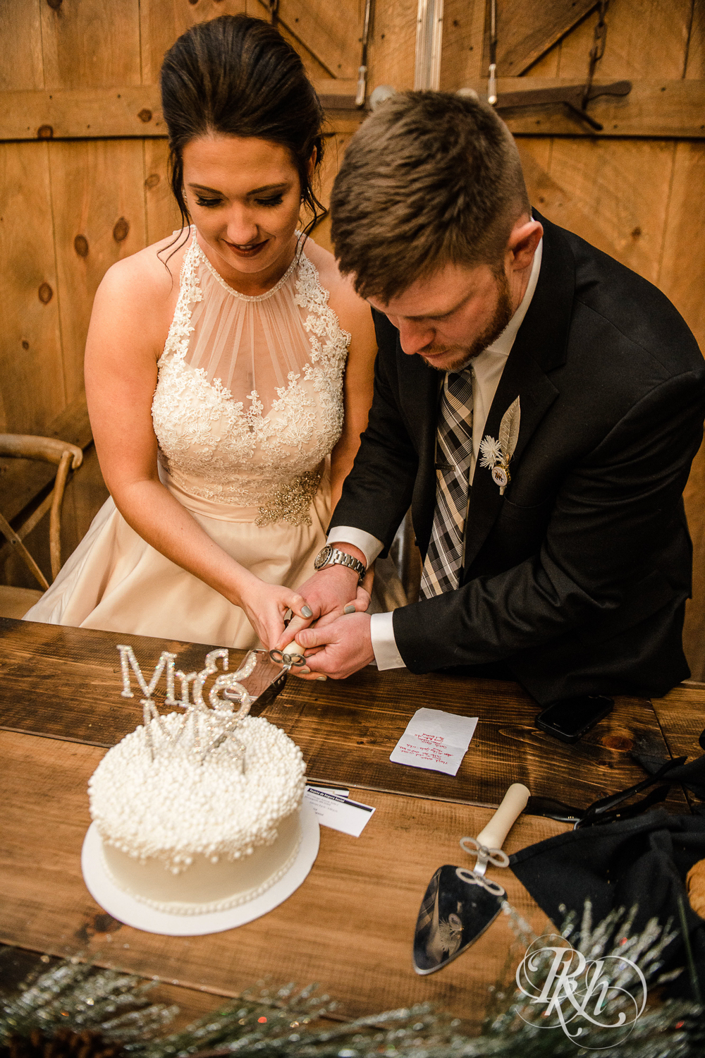 Bride and groom cut wedding cake during reception at Creekside Farm in Rush City, Minnesota.