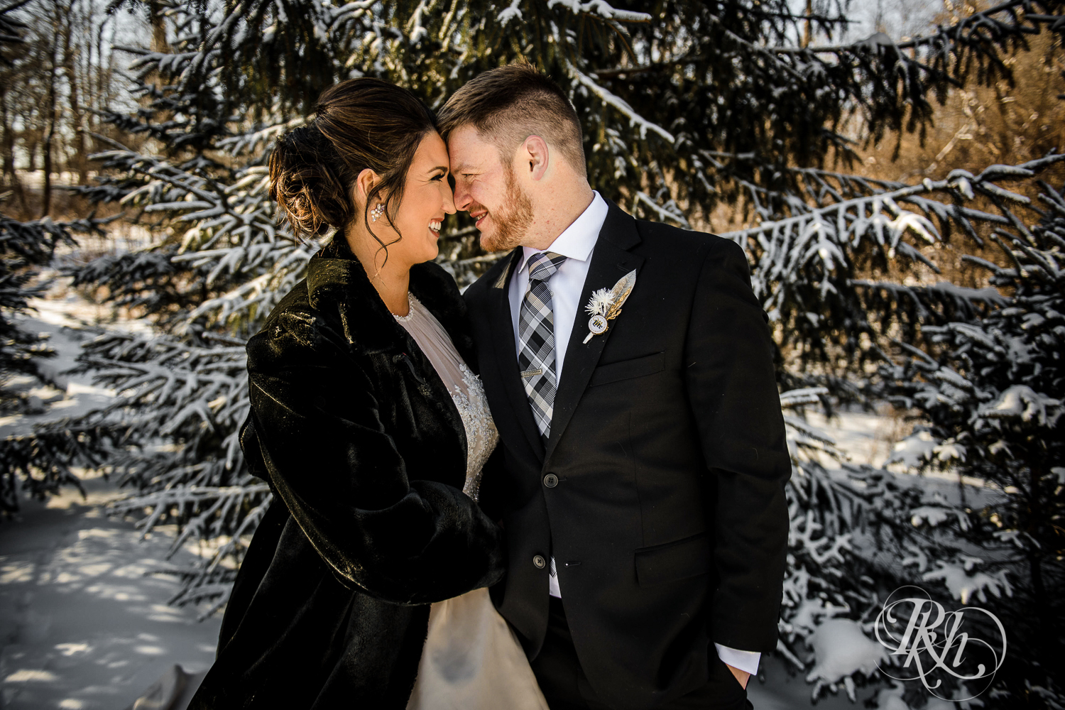 Bride and groom smile in the snow during winter wedding at Creekside Farm in Rush City, Minnesota.