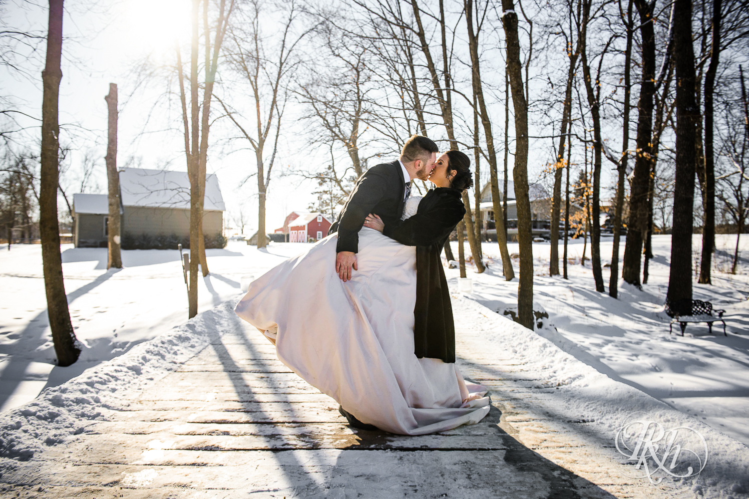 Bride and groom kiss in the snow during winter wedding at Creekside Farm in Rush City, Minnesota.