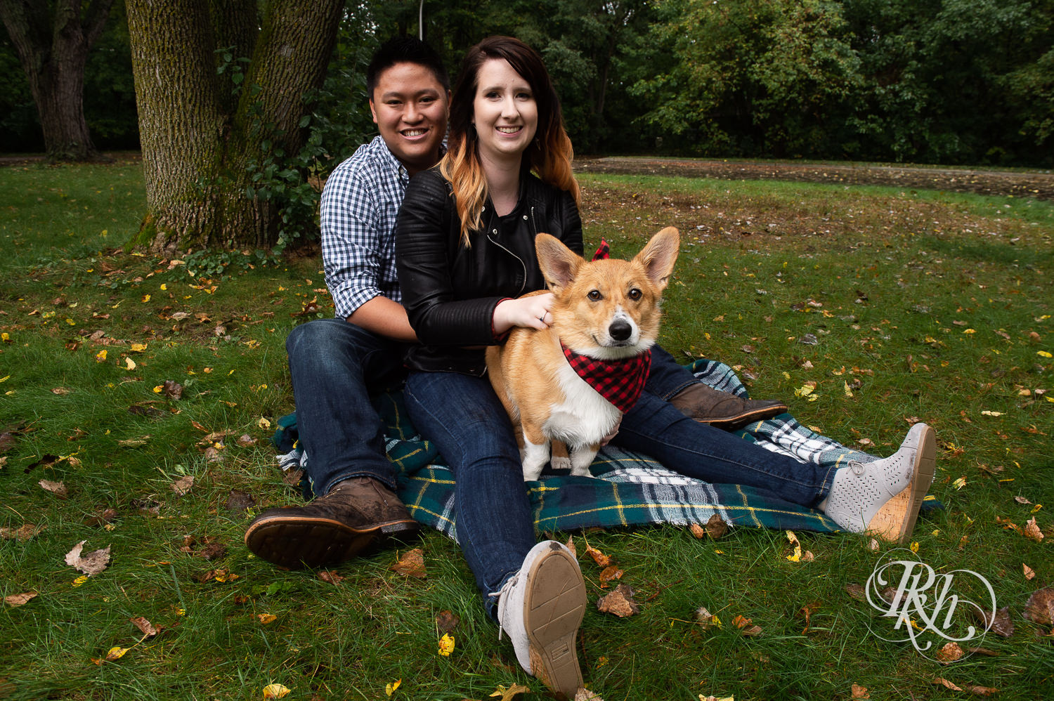 Asian man and woman smile with Corgi at Wood Lake Nature Center in Richfield, Minnesota.