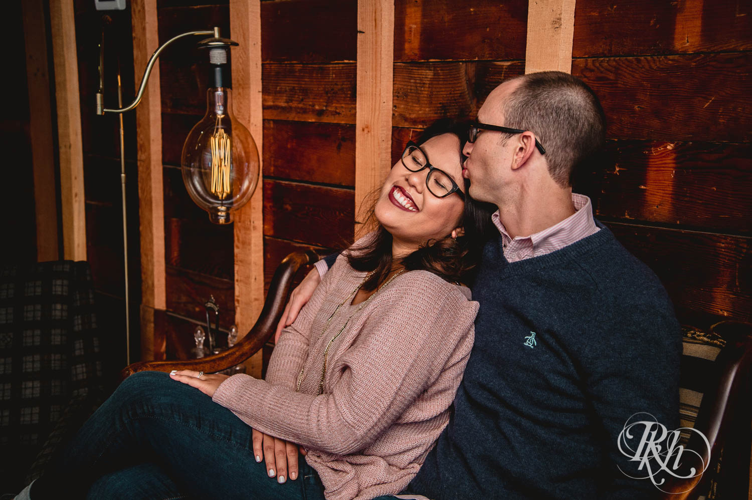 Man and Asian woman in glasses kiss for Young Joni engagement photos in Minneapolis, Minnesota.