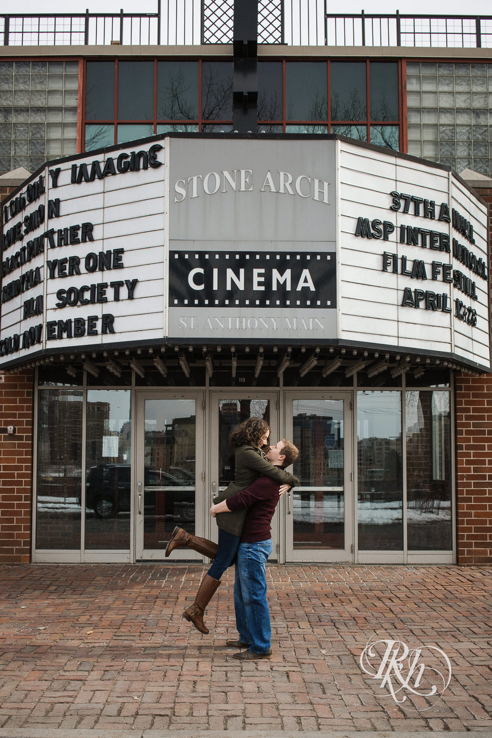 Man lifts woman in front of the Stone Arch Cinema in Minneapolis, Minnesota.