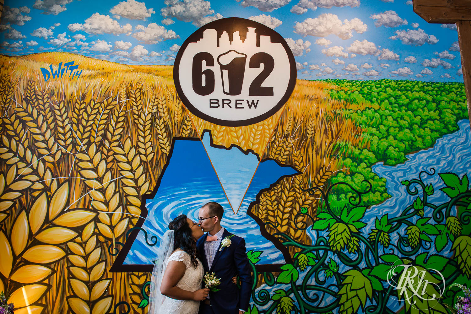 Bride and groom kissing under 612 Brew sign