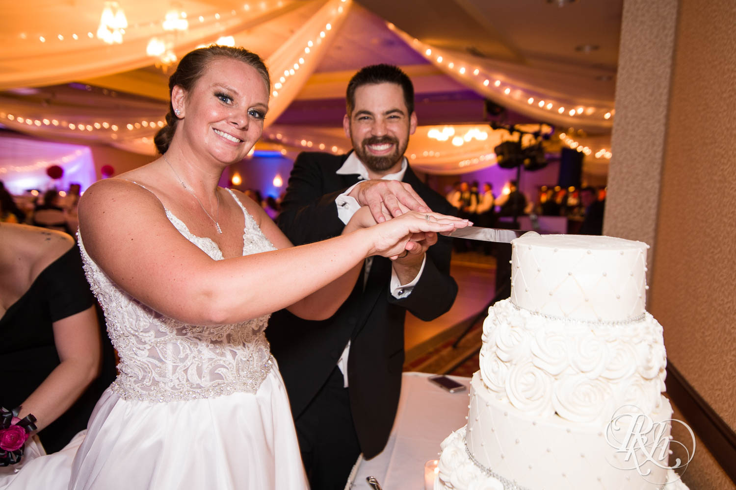 Bride and groom cut wedding cake at Crowne Plaza Minneapolis Northstar Downtown in Minneapolis, Minnesota.