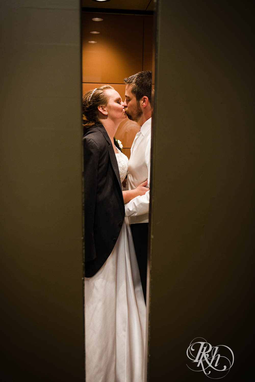 Bride and groom kiss in elevator at Crowne Plaza Minneapolis Northstar Downtown in Minneapolis, Minnesota.