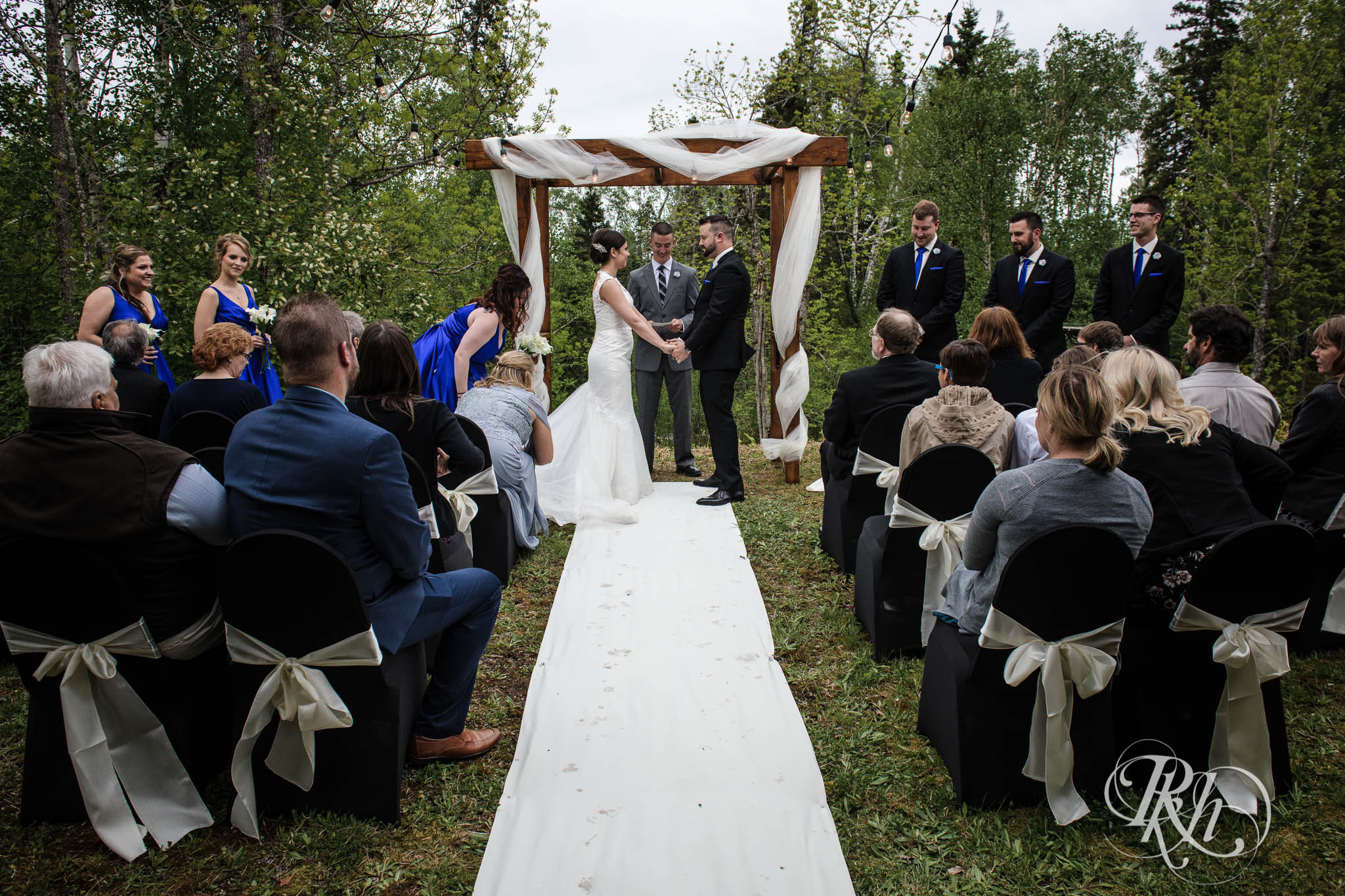 Bride and groom smile in backyard ceremony setup in the North Shore in Minnesota.