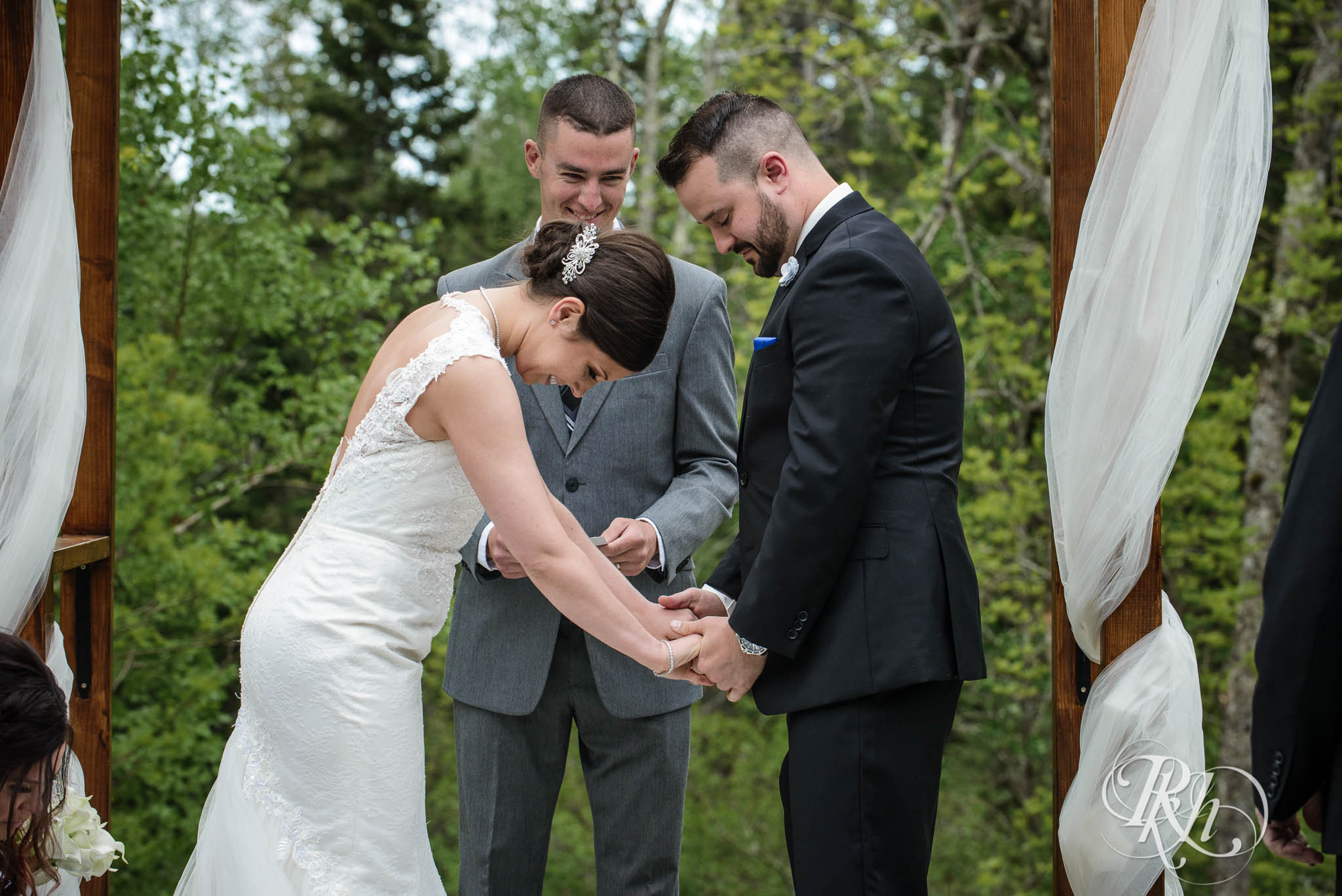 Bride and groom laugh during backyard wedding ceremony in North Shore in Minnesota.