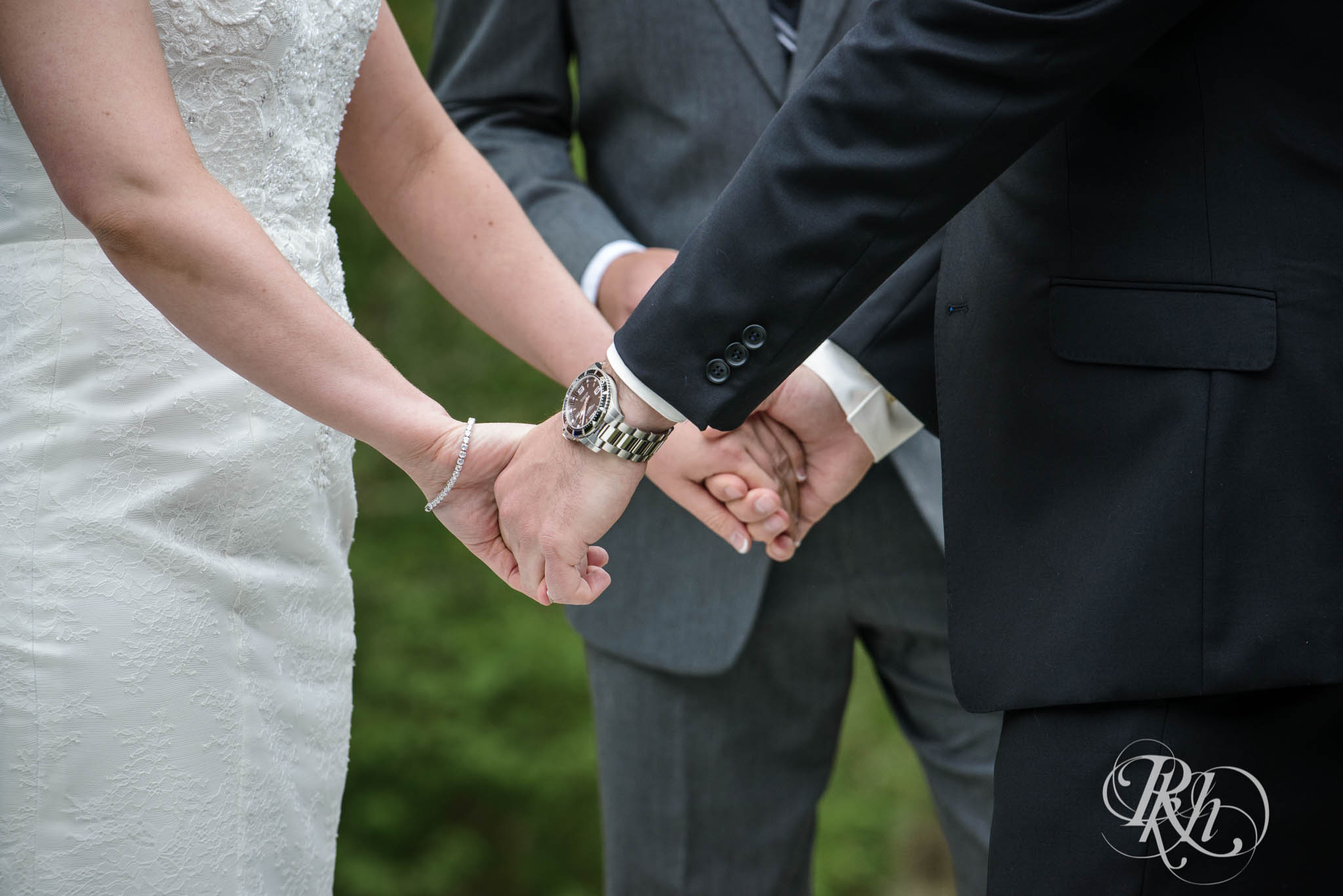 Bride and groom hold hands during backyard wedding ceremony in North Shore in Minnesota.