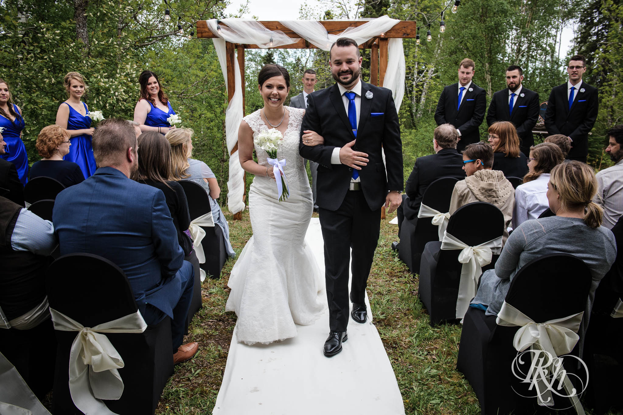 Bride and groom smile during backyard wedding ceremony in North Shore in Minnesota.