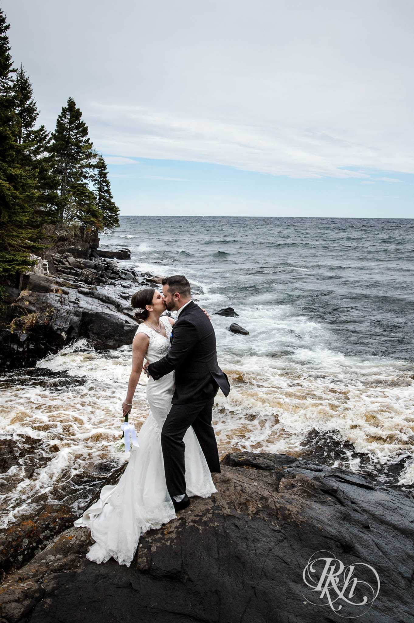 Bride and groom kiss in front of Lake Superior in North Shore in Minnesota.