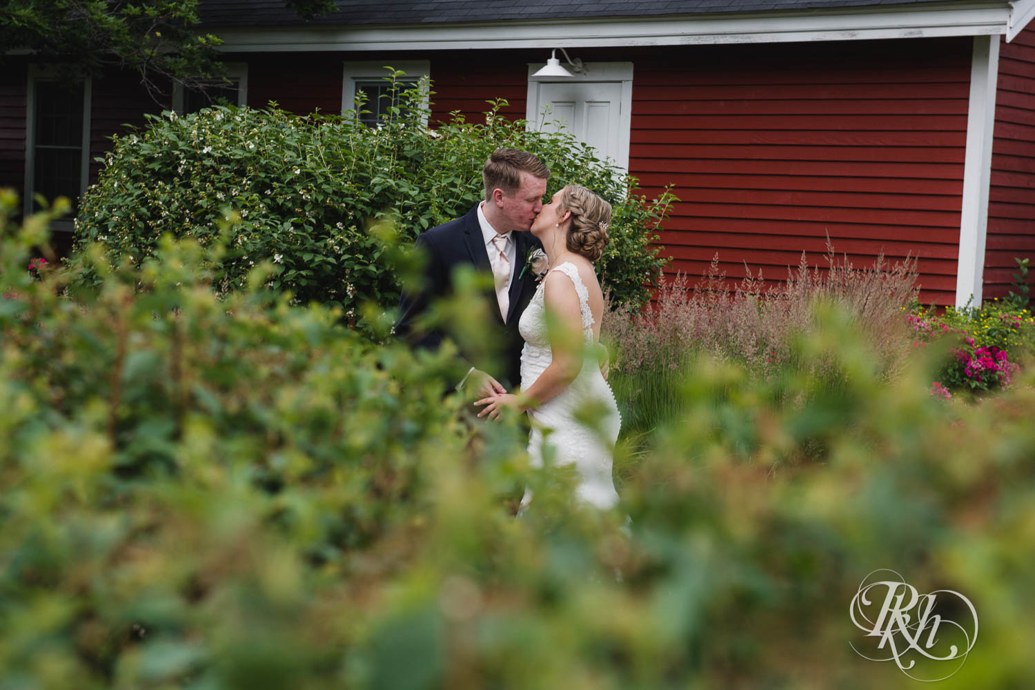 Bride and groom kiss on wedding day at Earle Brown Heritage Center in Brooklyn Center, Minnesota.
