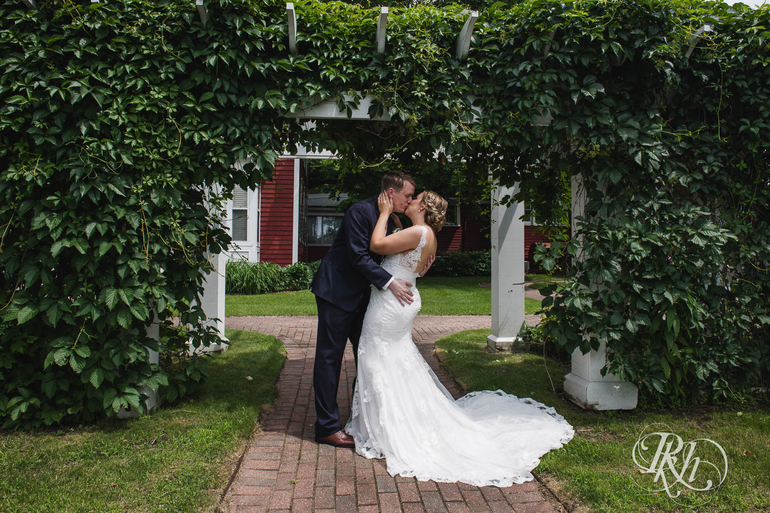 Bride and groom kiss on wedding day at Earle Brown Heritage Center in Brooklyn Center, Minnesota.
