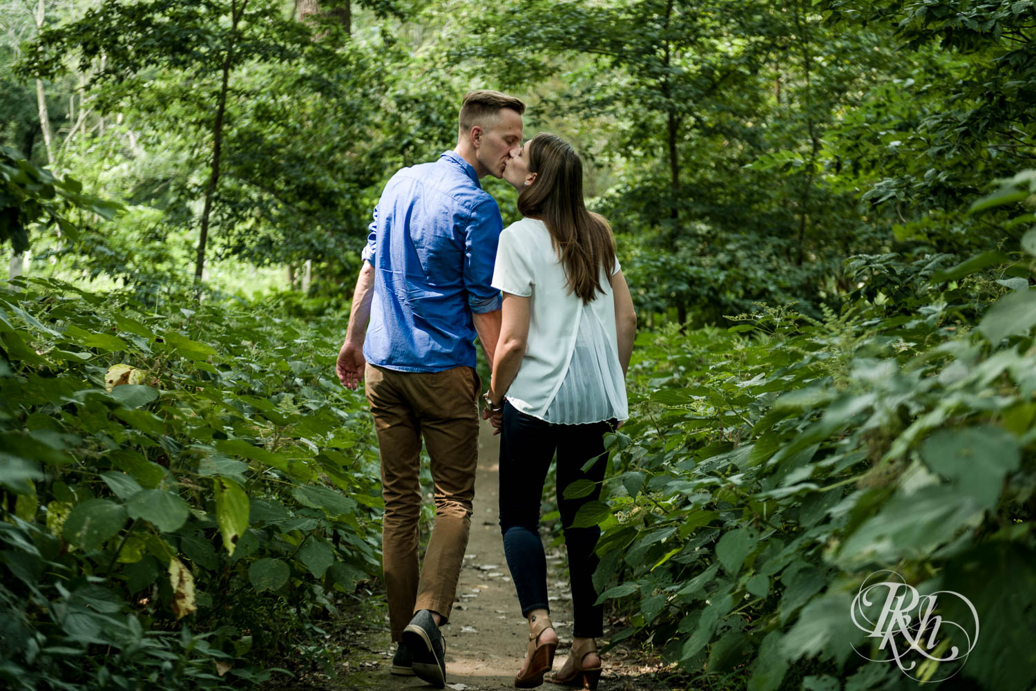 Man and woman kiss during engagement photos at Hidden Falls Regional Park in Saint Paul, Minnesota.