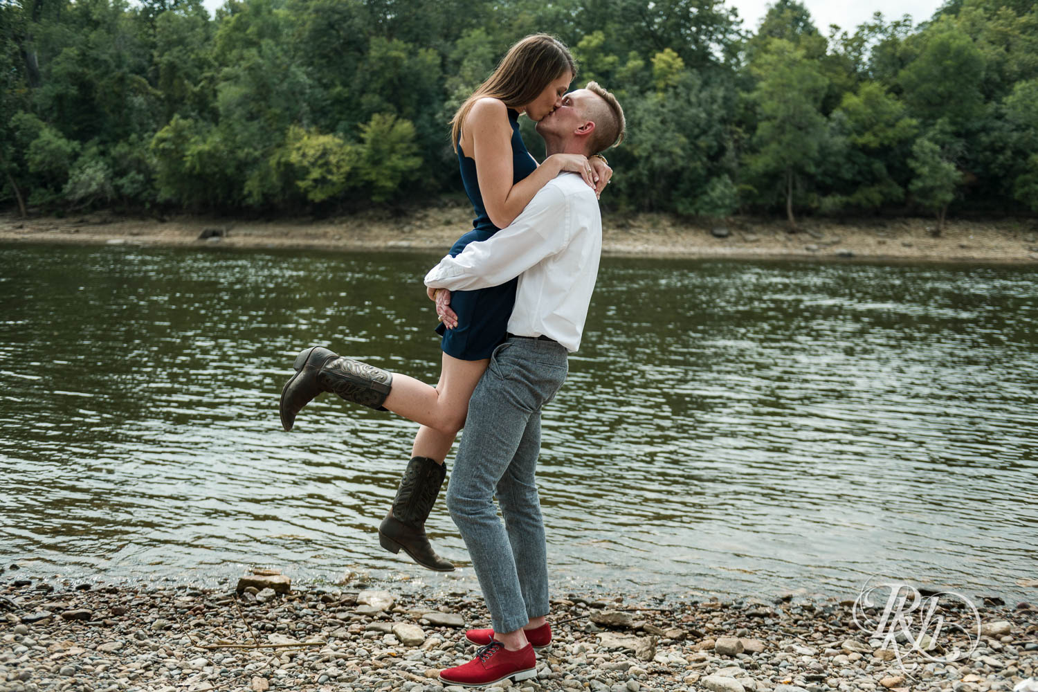 Man and woman kiss during engagement photos at Hidden Falls Regional Park in Saint Paul, Minnesota.