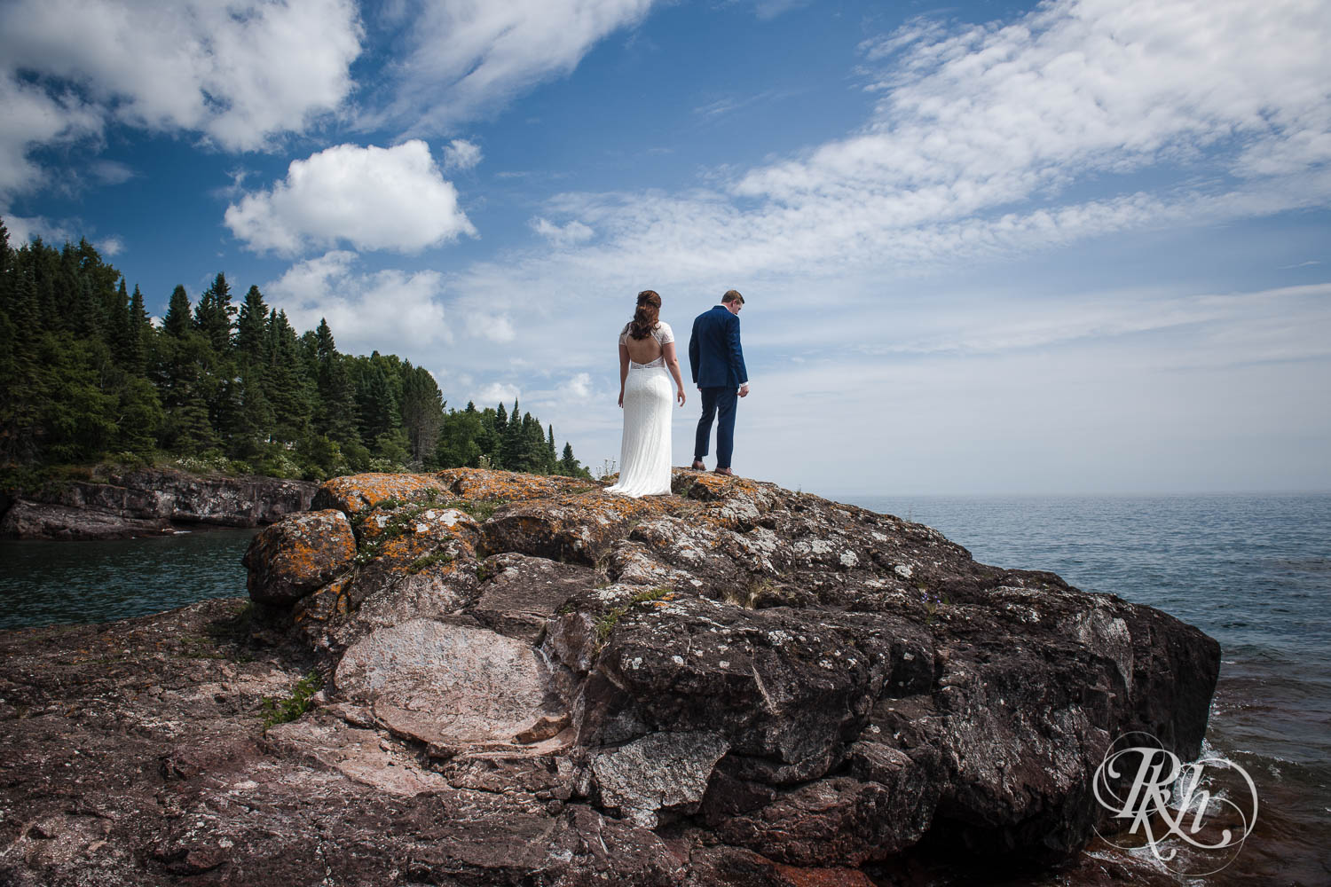 Bride and groom do first look on cliff in Bluefin Bay in Tofte, Minnesota.