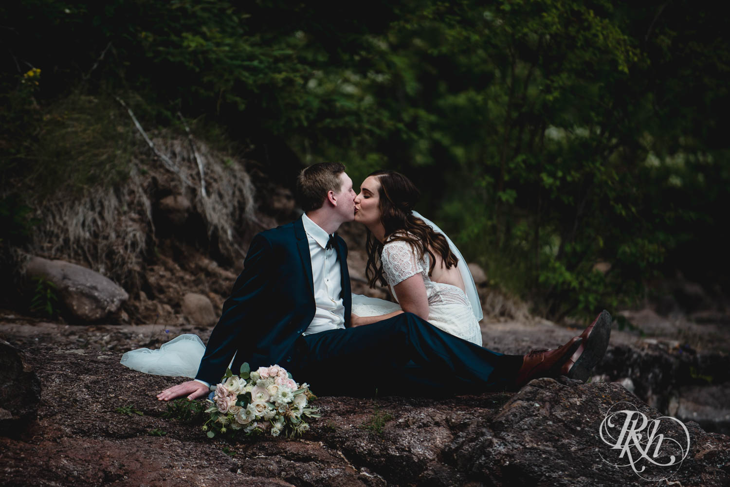 Bride and groom kiss on cliff in Bluefin Bay in Tofte, Minnesota.